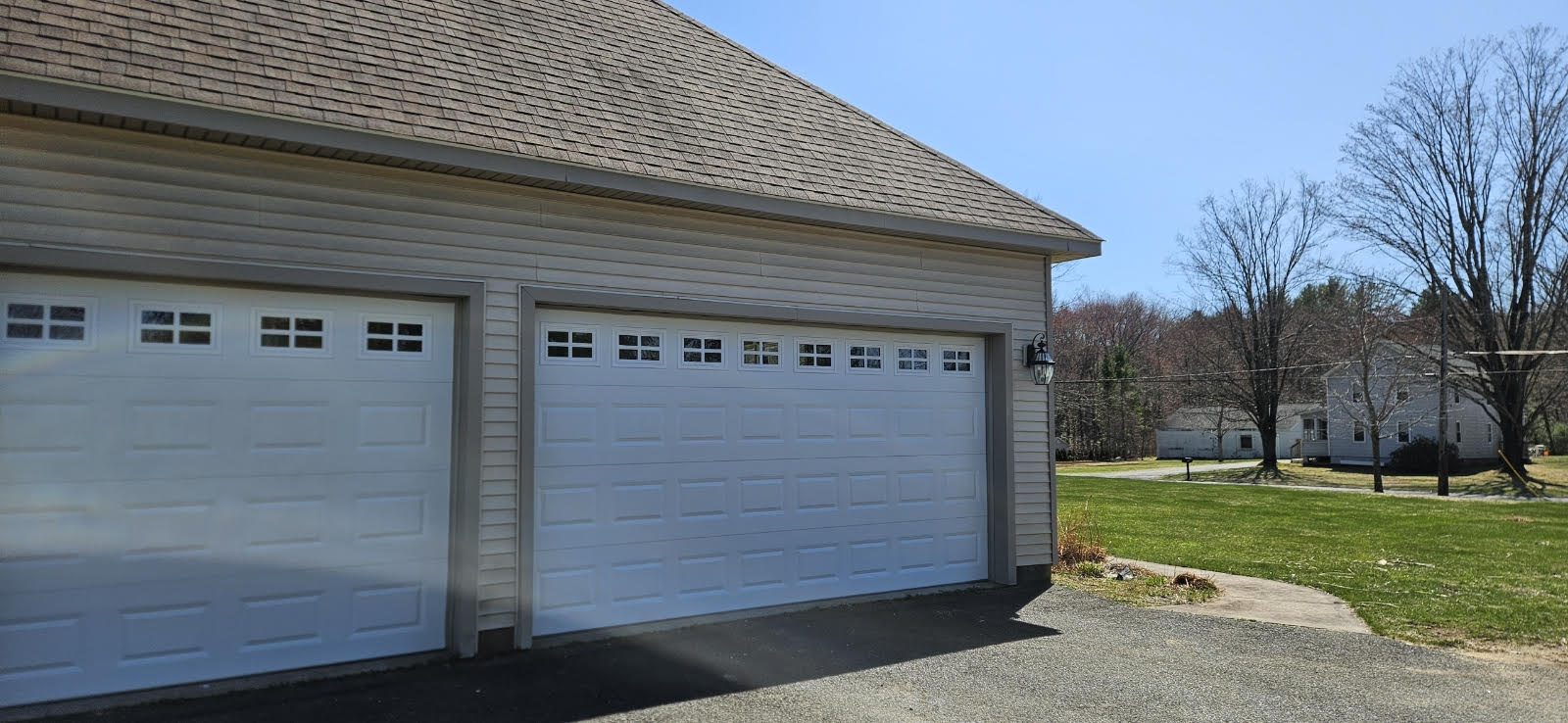 two garage doors and green grass at residential home in Southwick MA
